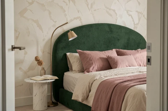 Chambre tendance avec tête de lit en bouclé vert forêt, linge de lit en lin écru et lampe arquée de style contemporain